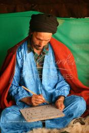 Image du Maroc Professionnelle de  Sous une tente on découvre la méthode traditionnelle de l’enseignement et l’apprentissage du saint coran prodigués aux enfants. Les jeunes récitent les sourates devant le Fkih (instituteur) qui écoute attentivement les versets ainsi récités, Samedi 18 septembre 2006, aux environ de Tan Tan dans un site désertique sur lequel la ville, a toujours accueilli la majorité des tribus et des grandes familles nomades du désert lors d'un grand Moussem, danses chants, course de chameaux et fantasia font partie des festivités. (Photo / Abdeljalil Bounhar)

